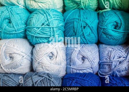 A full frame photograph of balls of wool stacked on a shelf Stock Photo