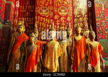 Ancient golden and wooden Buddha images in the picturesque temple of Wat Visoun, Luang Prabang, Laos. The temple is open to the public. Stock Photo