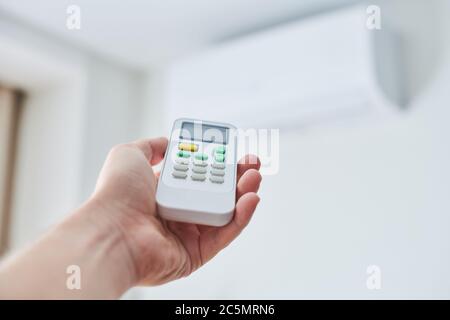 Remote control for air conditioner in hand. Room condition remote control. Air temperature switch for cooling of space. Stock Photo