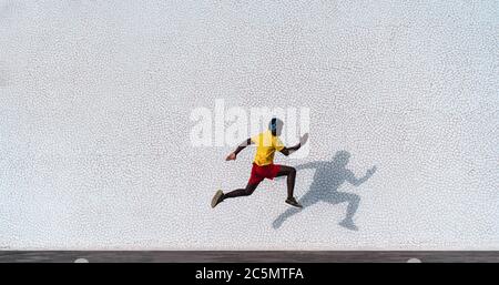 Young black man doing workout routine at morning time while running outdoor - Fit african runner doing cardio training - Fitness and sport concept - F
