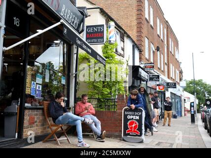 London, UK. 4th July 2020 A barbers shop in Twickenham generates a queue as they open for business after lockdown is eased in England. Credit: Andrew Fosker / Alamy Live News Stock Photo