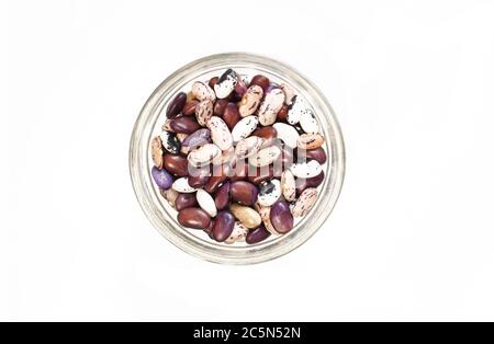 All kinds of kidney beans in a small glass bowl isolated on white background. Top view Stock Photo
