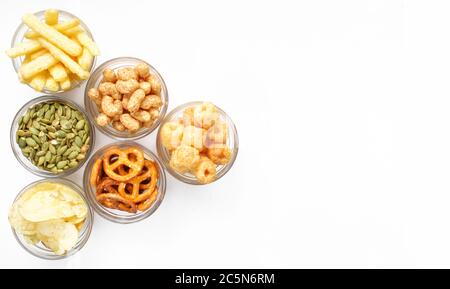 Different snacks and crisps isolated on white background. Set of treats. Top view. Above Stock Photo