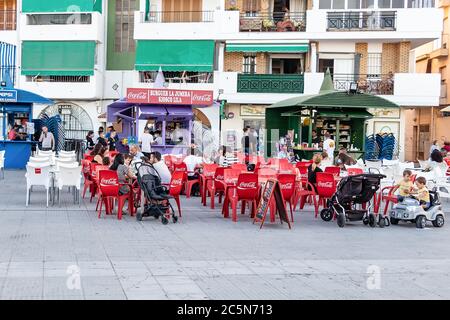 Punta Umbria, Huelva, Spain - June 3, 2020: People sitting in terrace of a cafe and bar, are wearing protective mask due to covid-19. Huelva, Spain Stock Photo