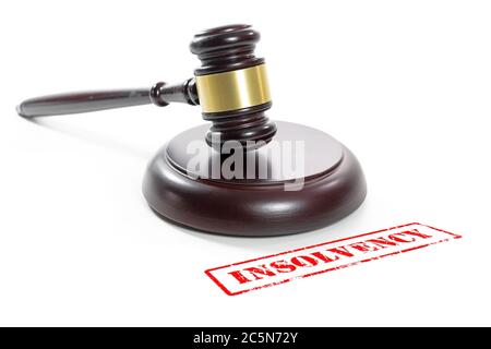 Judge gavel and a red stamp with the word Insolvency, companies are going bankrupt due to the coronavirus crisis, isolated on a white background Stock Photo