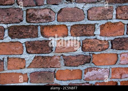 background made with old and handmade reddish bricks of slightly different shapes from each other Stock Photo