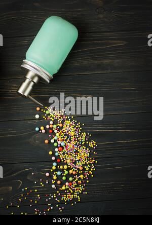 Bottle with air pump dispenser full of liquid soap on a black background. Liquid soap on the table. Blue bottle with metallic dispenser on a black Stock Photo