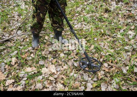 metal detector in the forest and a man digging coins. Search old coins ...