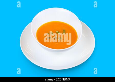 Pumpkin cream soup with seeds isolated on a blue background Stock Photo