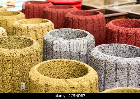 stone trash can in an assortment of new multi-colored garbage cans closeup. Stock Photo