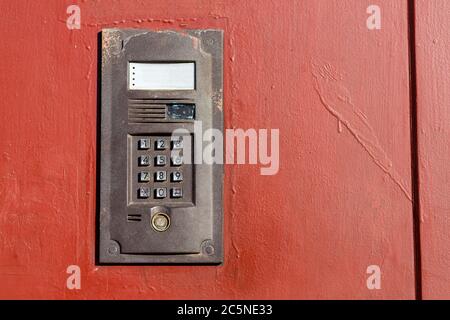 an intercom on metall used door with a keypad for calling close up with copy space. Stock Photo