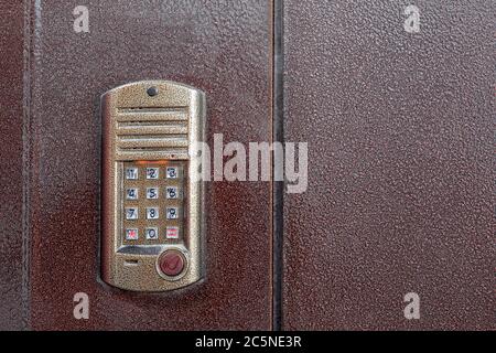 an intercom on metall door with a keypad for calling and a scanner key chip for access close up with copy space. Stock Photo