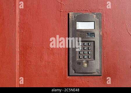 an intercom on metall old door with a keypad for calling close up with copy space. Stock Photo