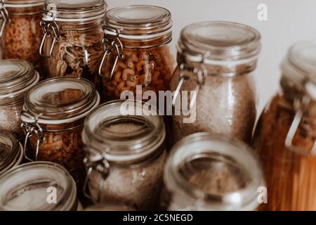 Glass jars full with dried uncooked food ingredients Stock Photo