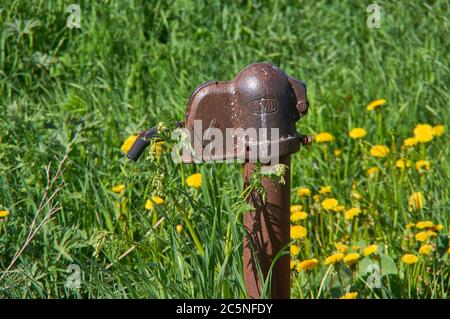 Old rusty water column in the village close up Stock Photo