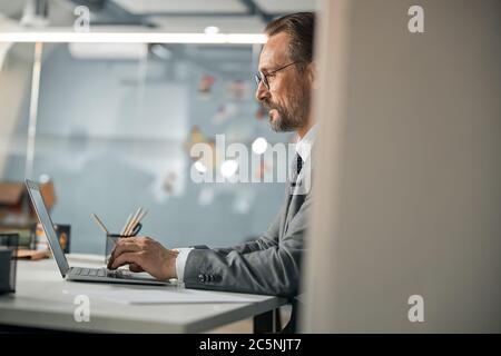 Middle age man working in office with laptop Stock Photo