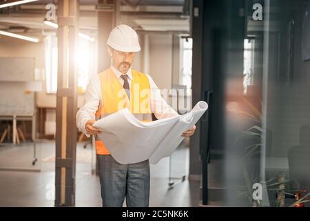 Portrait of a successful builder in a white helmet and business suit Stock Photo