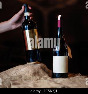 Woman taking new wine bottle on a dark background Stock Photo