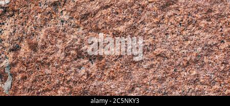 Background granite is a red stone with small black and white spots on the entire surface. Texture for an inscription, text, or logo. Stock Photo