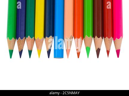 Many different colored wood pencil crayons placed in a line on a paper background Stock Photo