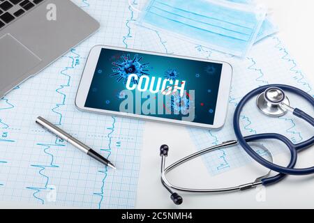 Tablet pc and doctor tools on white surface with COUGH inscription, pandemic concept Stock Photo
