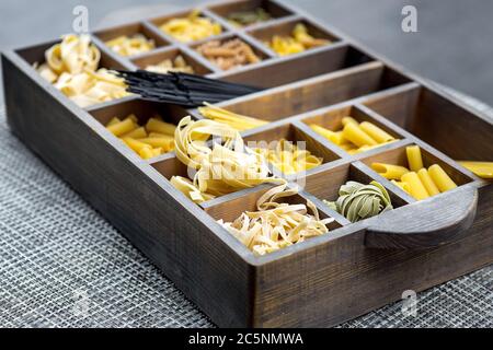 Traditional Italian food in the cells of a wooden box on the table. Stock Photo