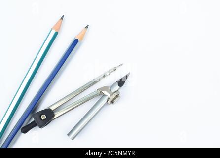 Two different colored wood pencil crayon placed beside one still pencil compass Stock Photo