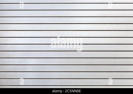 horizontal iron roller shutters of gray color close-up, metal gate texture. Stock Photo