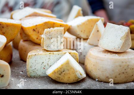 Hard varieties of goat cheese with spices close-up on the table. Stock Photo