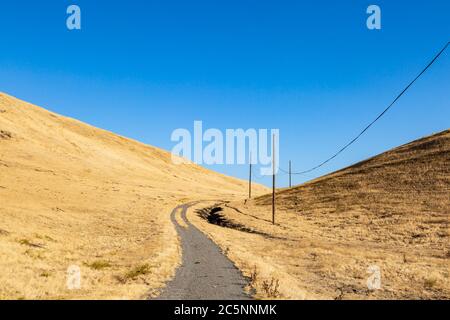 Telephone lines in the dry Californian countryside, early on a sunny morning Stock Photo