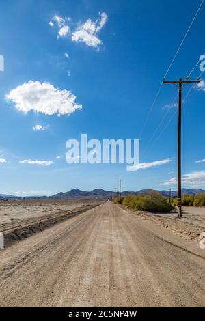 Looking along a long dusty unpaved road in rural California Stock Photo