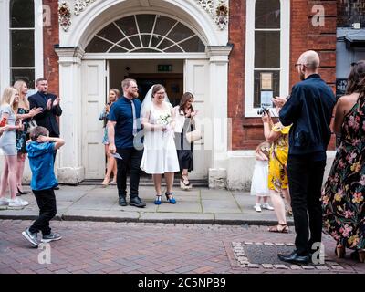 Rochester, Kent UK. 4th July, 2020. A newly wed couple exit Medway Registry Office. The U.K reopens pubs, restaurants, barbers, hairdressers and hotels on July 4th after being closed since March due to the Coronavirus Outbreak. Credit: Yousef Al Nasser/ Alamy Live News Stock Photo