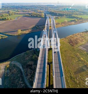 New modern double cable-stayed bridge with wide three-lane roads over Vistula River in Krakow, Poland. Part of the ring road around Krakow. Aerial vie Stock Photo