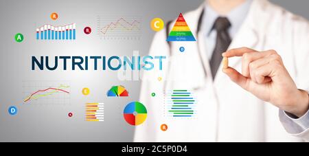 Nutritionist giving you a pill with NUTRITIONIST inscription, healthy lifestyle concept Stock Photo