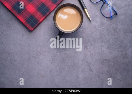 flat composition coffee, notepad and eyeglass on black background . Stock Photo