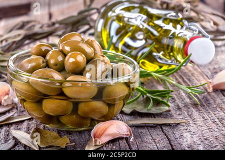 Olives in the bowl with olive oil. The concept of healthy eating and nutrition. Vintage style composition on a rustic table. Stock Photo
