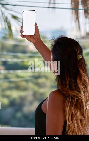 smartphone screen cutout, latin woman with using smartphone, augmented reality, taking selfi, Stock Photo