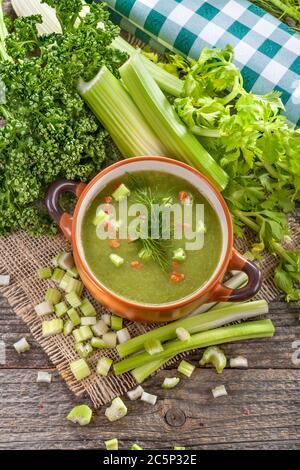 Potage soup made from fresh domestic celery with spices. Ripe sweet healthy organic potage soup in a bowl on the old rustic table. Stock Photo