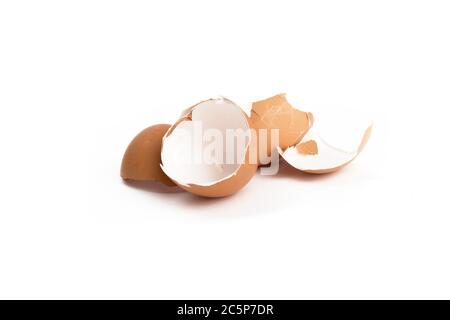 broken brown eggshells in a heap isolated on white Stock Photo