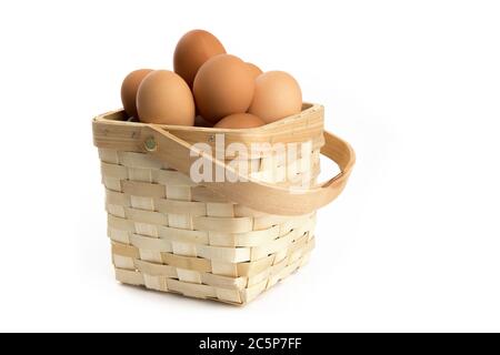 a wooden basket of eggs fresh from the chicken coop isolated on white Stock Photo