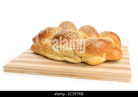a braided loaf of sesame egg bread on a wooden cutting board  isolated on white Stock Photo