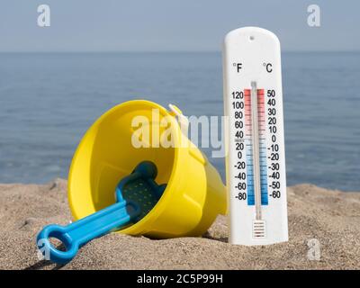 A Thermometer In The Hot Sand On The Beach Showing About About 90 Degrees Fahrenheit 33 Celsius With A Child S Sand Toy Pail Stock Photo Alamy