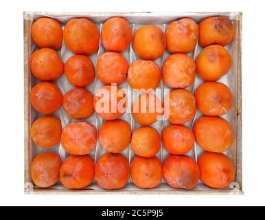 Persimmon fruit in the wooden box isolated on white. Clipping Path included Stock Photo