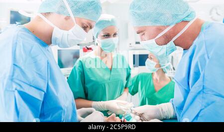 Surgeons or doctors in operating room of hospital Stock Photo