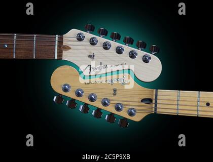 Two Fender Stratocaster electric guitars involved in a mating ritual. Stock Photo