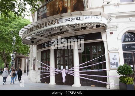 London, UK, 4 July 2020: The Playhouse Theatre is decorated with tape saying 'Missing Live Theatre #sceneschange', part of a campaign todraw attention to the funding crisis in British theatre. The Playhouse should have been enjoying a run of The Seagull, starring Game of Thrones actor Emilia Clarke, but like all others in the UK has had to close it's doors due to coronavirus. Anna Watson/Alamy Stock Photo