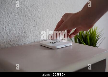 Wireless Headphones being placed on wireless charging pad to charge battery Stock Photo