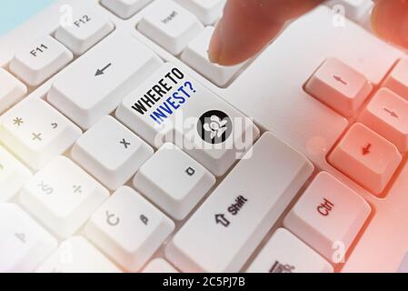 Handwriting text writing Where To Invest Question. Conceptual photo fundraising money to start business project startup Pc keyboard key with pointing Stock Photo