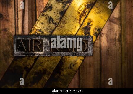 Air Raid text formed with real authentic typeset letters on vintage textured silver grunge copper and gold background Stock Photo