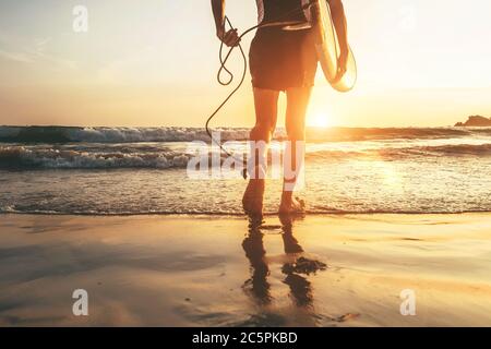 Man surfer runing in ocean with surfboard.  Close up legs image at Weligama beach,Sri Lanka Stock Photo